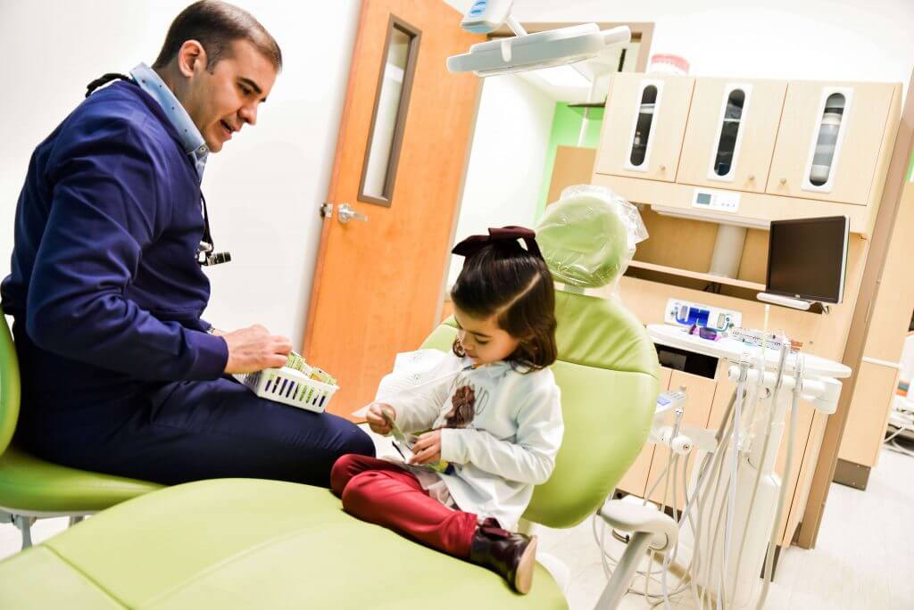 Dr. Lopez, a pediatric dentist in Edinburgh, TX, treating a young patient at GigglesVille Pediatric Dentistry