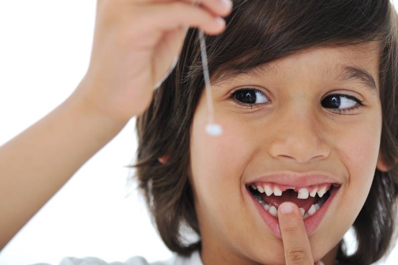 pediatric patient holding his tooth after a visit to our pediatric dentist in Edinburg for a dental emergency