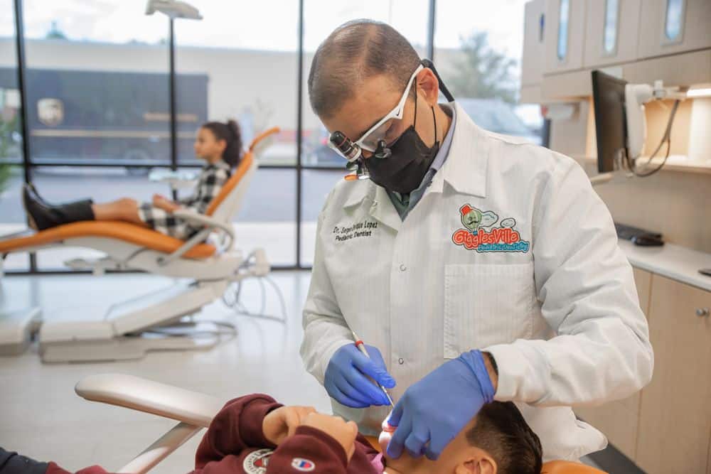 Dr. Lopez, a pediatric dentist in Edinburg, TX, performing a dental check up on a young patient